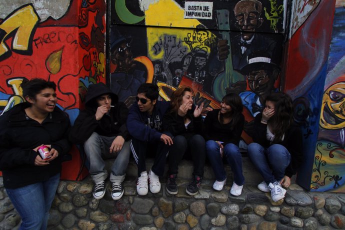 Teenagers smoke and talk in front of a vacant business in Ushuaia, Argentina, De