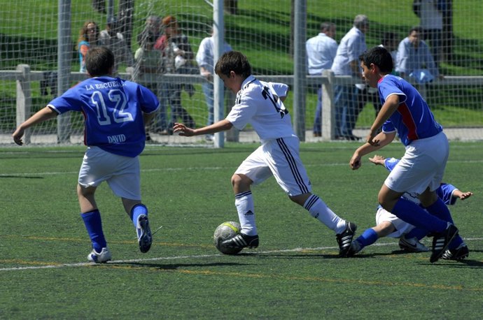 Niños juagando al fútbol, campo de fútbol