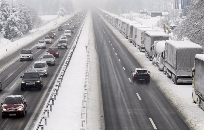 Camiones cubiertos de nieve estacionados en una autopista en Brezovica