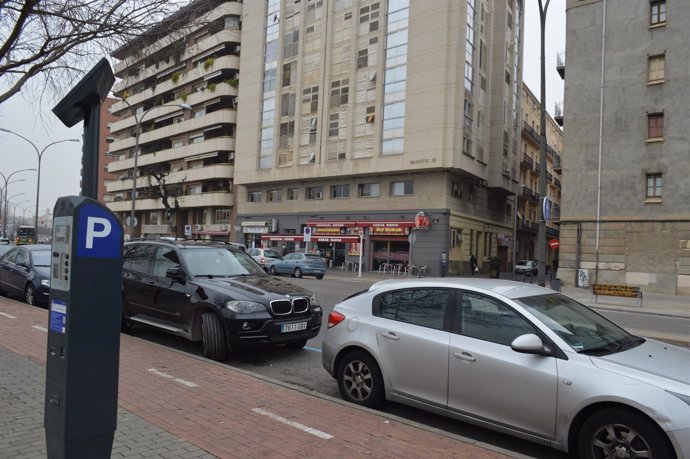 Parquímetro en una calle con coches aparcados en Lleida