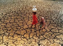 Dos niñas caminan por un terreno agrietado por la sequía