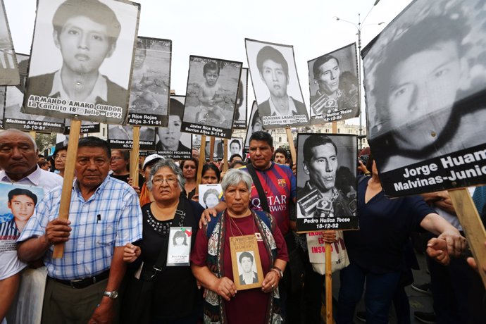 People holding pictures of victims of the guerrilla conflict in the 80s and 90s 