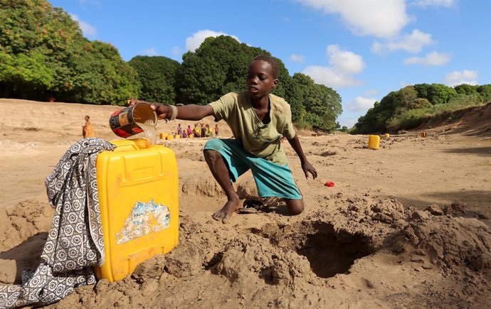 Un niño somalí recolecta agua de un pozo cerca del río Shabelle 