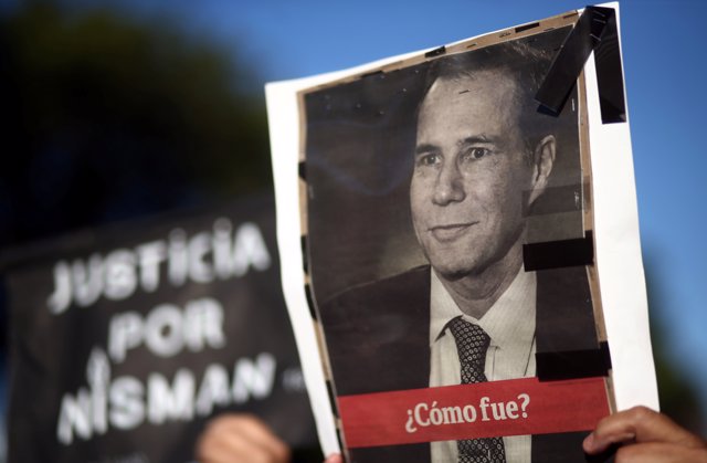 A woman holds up a photo of late state prosecutor Alberto Nisman, lead investiga