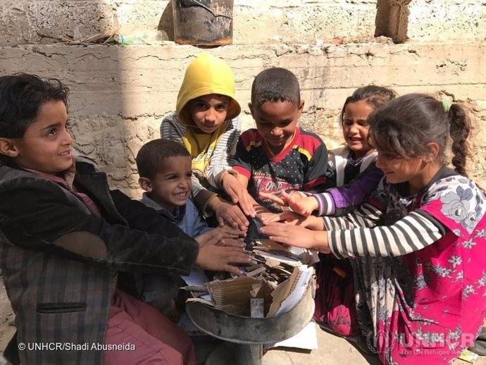 Niños desplazados calentándose las manos en Yemen