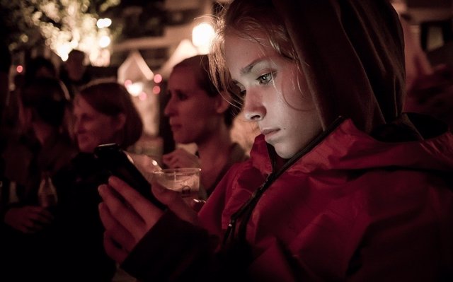 Niña usando un smartphone en una celebración 