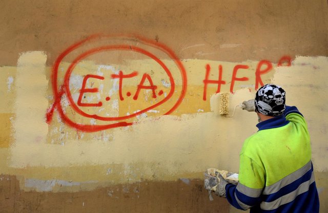 Un hombre borra una pintada de ETA en Guernica, Euskadi