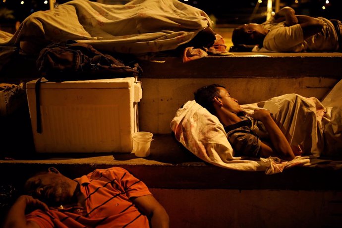 Un grupo de venezolanos duerme a la intemperie en una cancha en Colombia.