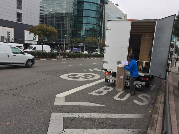 Un hombre descarga un paquete de un camión