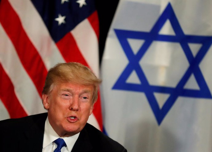 Donald Trump frente a las banderas de Estados Unidos e Israel