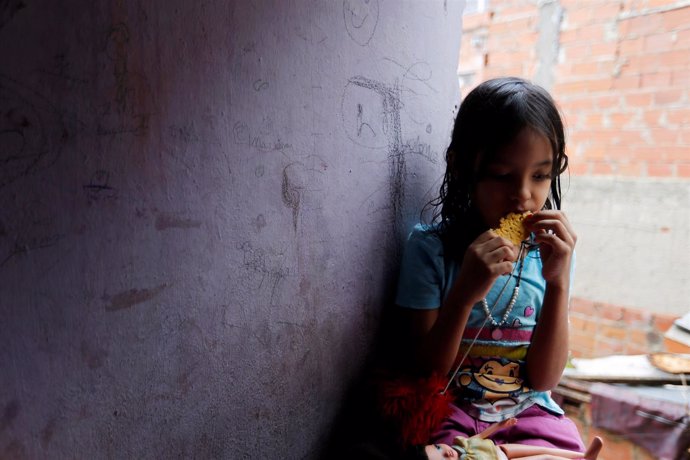Una niña en Venezuela comiendo una arepa