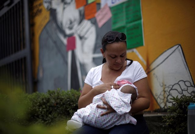 A woman breastfeeds her baby during a "Mamathon" demonstration, as part of the c
