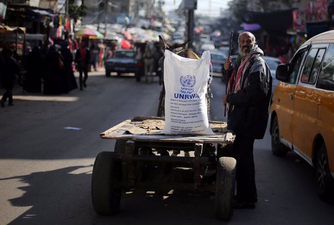 Un palestino junto a un saco de harina de la UNRWA en la Franja de Gaza