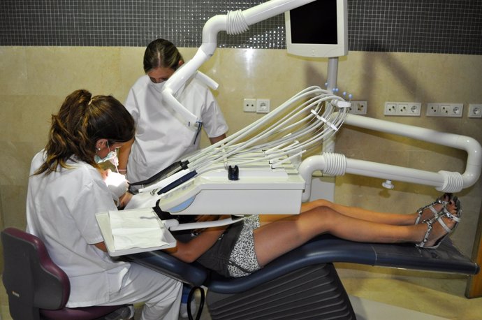 Dentistas Tratan A Una Paciente En Consulta