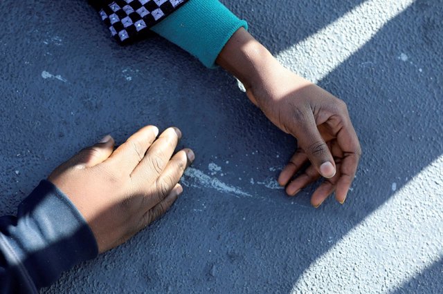 Las manos de dos inmigrantes rescatados frente a la costa de Libia