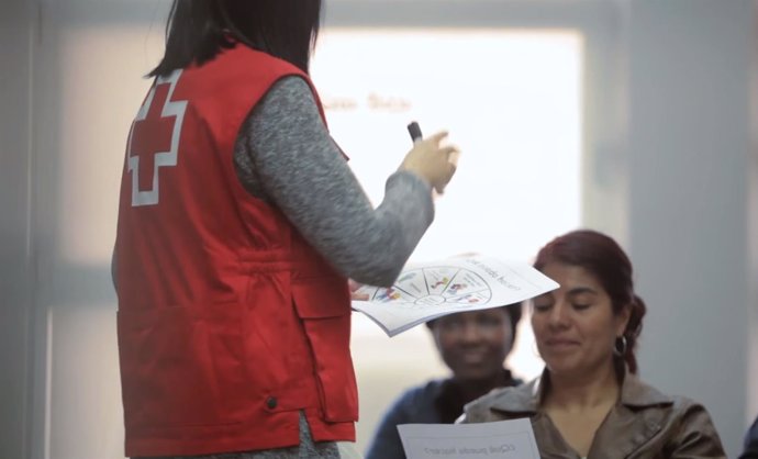 Una voluntaria de Creu Roja atiende a mujeres usuarias de la entidad