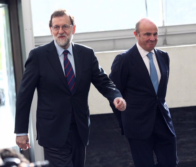 Luis de Guindos y Rajoy a su llegada a una jornada de la Cámara de Comercio