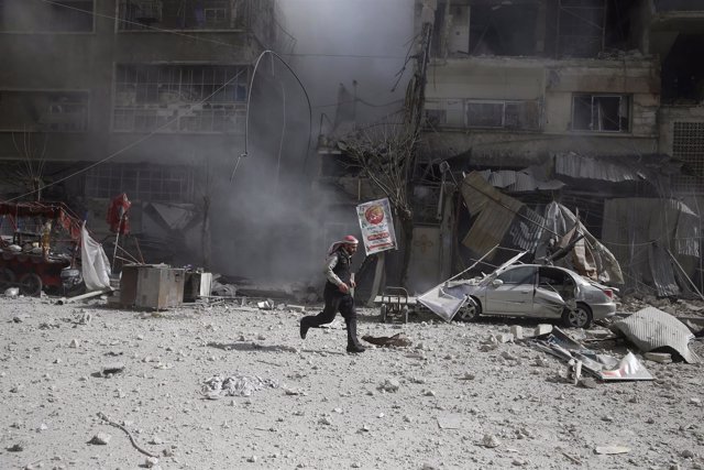 Un hombre corre tras un ataque aéreo en la ciudad siria de Duma
