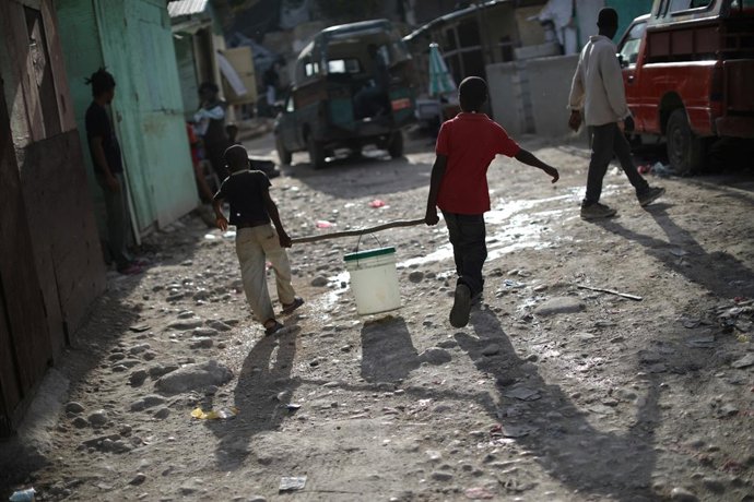 Niños transportan un cubo en Puerto Príncipe