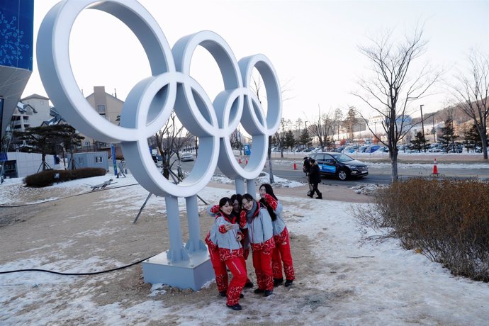 Voluntarios junto a los aros olímpicos en PyeongChang