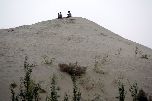 Uigures en una duna de arena en las afueras de Jotán (China)