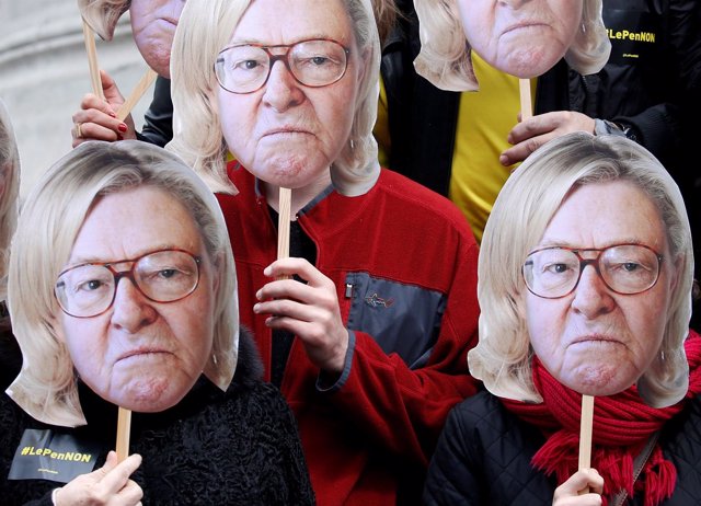 Activistas con las caras de Jean Marie le Pen y Marine le Pen