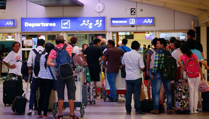 Decenas de turistas esperan en el aeropuerto internacional de Velana
