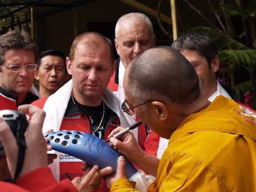 Dalai Lama firmando la antorcha olímpica