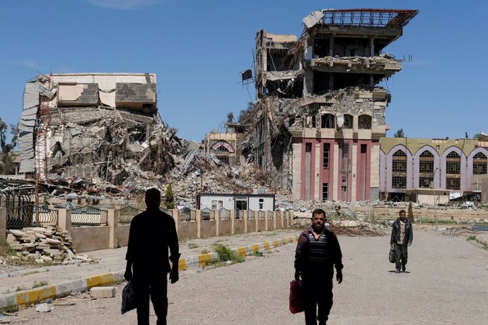 Personas frente a los restos de la Universidad de Mosul