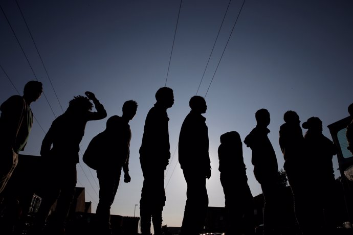 Migrantes hacen cola cerca de Calais