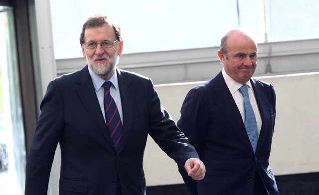 Luis de Guindos y Rajoy a su llegada a una jornada de la Cámara de Comercio