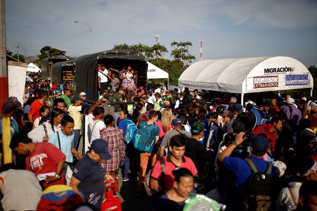 Venezuelan migrants get off the trucks escorted by police officers before they c