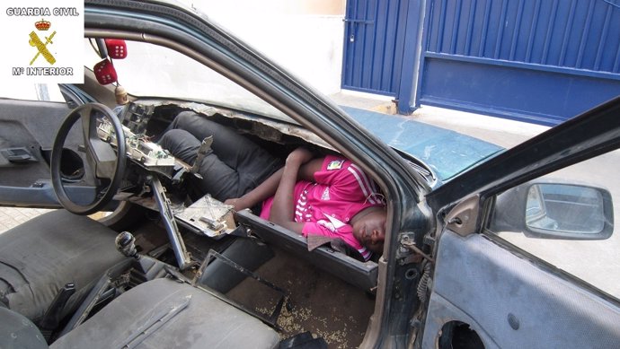 Inmigrante en el salpicadero de un coche en Melilla.