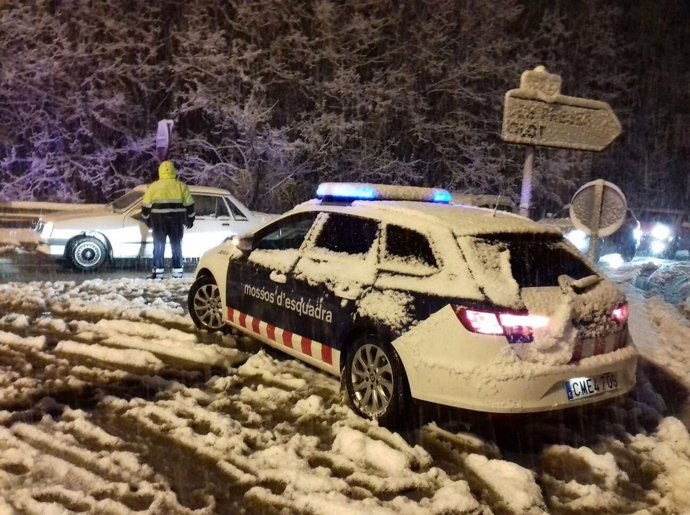 Cotxe dels Mossos d'Esquadra en una carretera amb neu