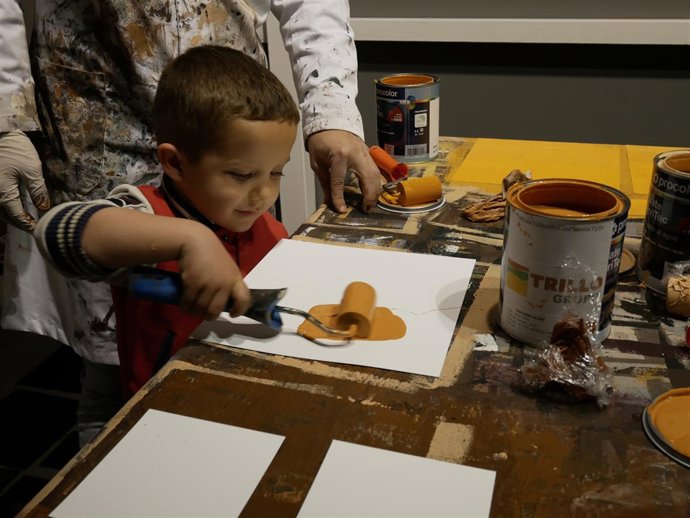 Un niño pinta una tesela que compondrá la réplica de la Inmaculada
