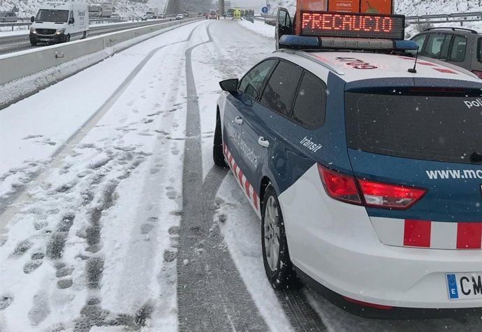 Cotxe dels Mossos d'Esquadra en una carretera amb neu