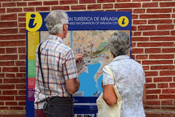 Turistas mirando un callejero de Málaga.