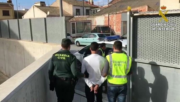 El detenido, custodiado por dos agentes