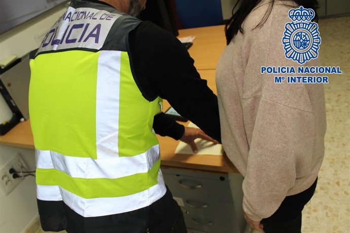 Un agente toma las huellas a una detenida