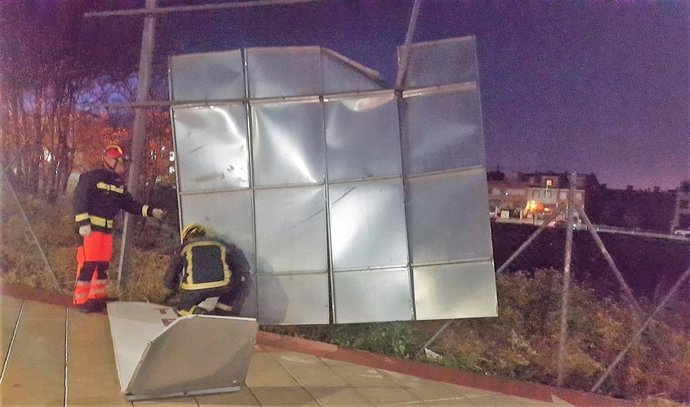 Bomberos intervienen para retirar una valla derribada por el fuerte viento
