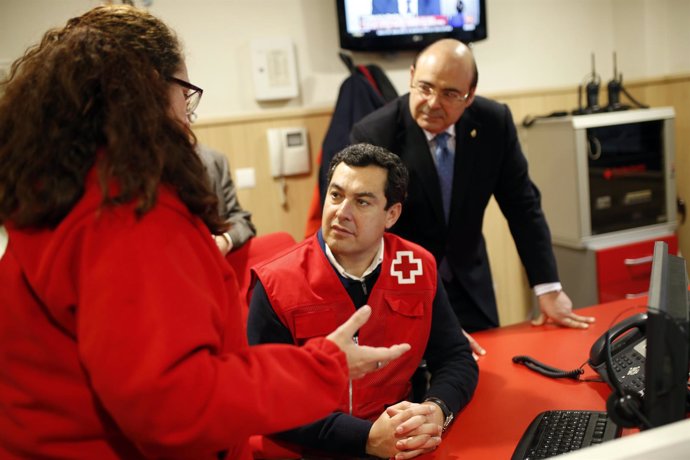 Juanma Moreno durante su visita a la sede de Cruz Roja en Granada