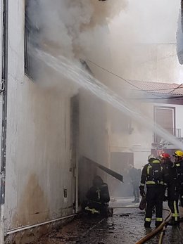 Tareas de refresco en un incendio en un almacén de muebles en Peligros (Granada)