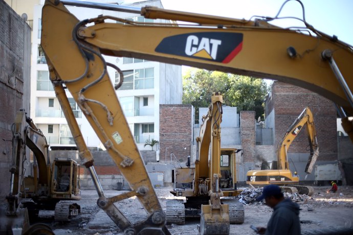 Diggers are pictured at a site where a building was demolished and where a memor