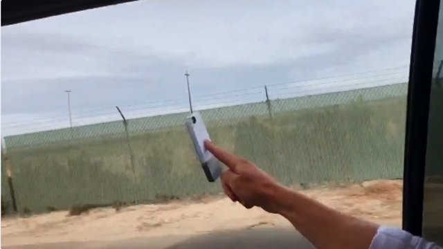 Joven sostiene con un dedo fuera de la ventana de un coche en marcha