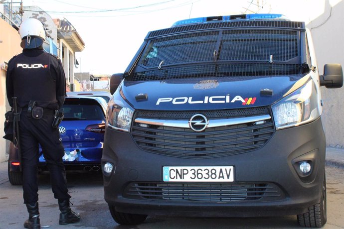 Un agente de Policía Nacional junto a su vehículo