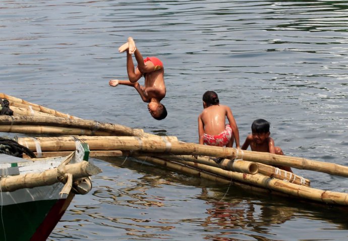 Foto de archivo de niños jugando en la Bahía de Manila. 