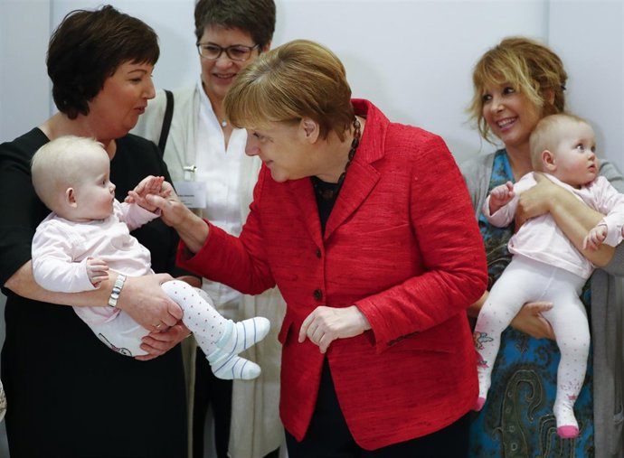 Foto de archivo de la canciller alemana, Angela Merkel, saludando a una bebé.