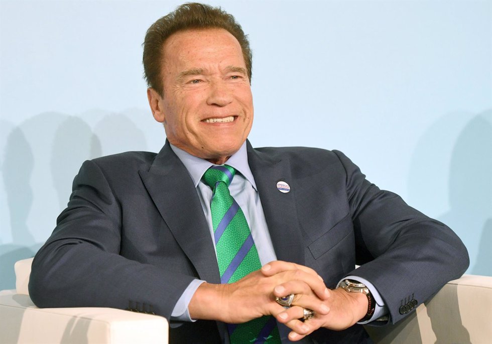 Former governor of California Arnold Schwarzenegger sits on the podium in the 