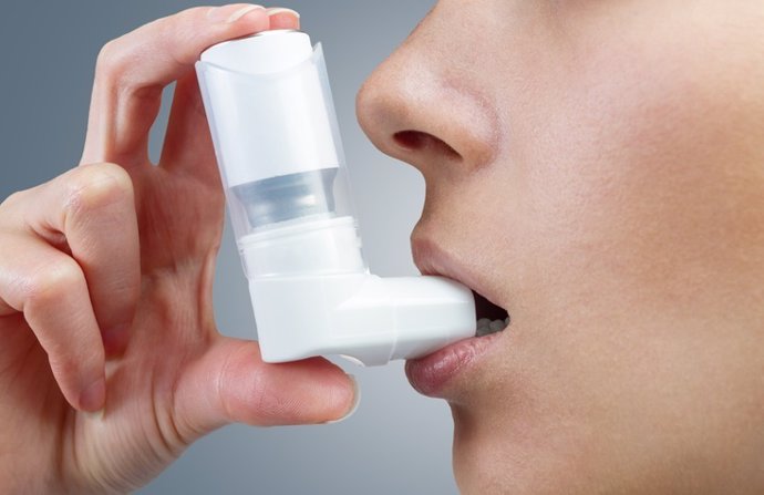 Mujer, asma, inhalador