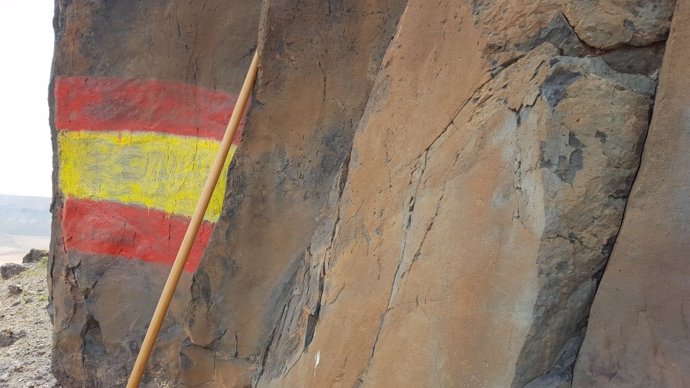 Pintada de una bandera de España sobre unos grabados pehispánicos